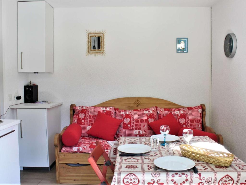 sala de estar con mesa y sofá con almohadas rojas en Appartement Risoul, 1 pièce, 4 personnes - FR-1-330-567, en Risoul