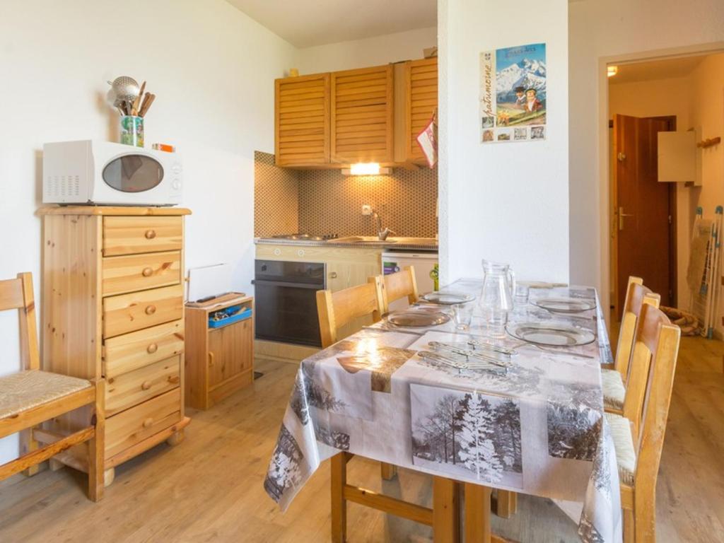 a kitchen with a dining room table with chairs and a kitchen at Appartement La Plagne Montalbert , 2 pièces, 5 personnes - FR-1-181-2723 in Aime-La Plagne