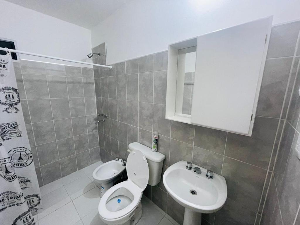 La salle de bains est pourvue de toilettes blanches et d'un lavabo. dans l'établissement Departamentos Isabella, à Villa Unión