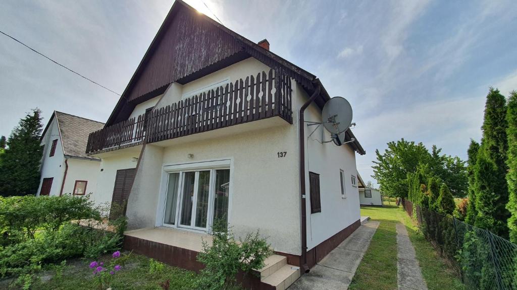 a white house with a black roof at Holiday home in Balatonlelle 38068 in Balatonlelle