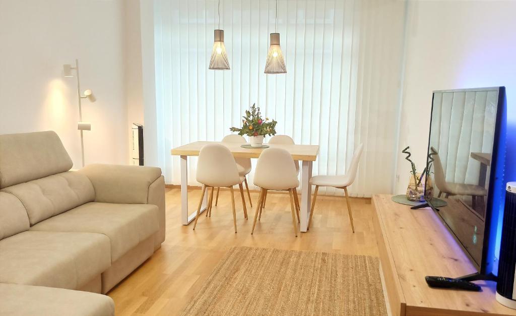 uma sala de estar com uma mesa e um sofá em Aronda Cambados apartamento céntrico em Cambados