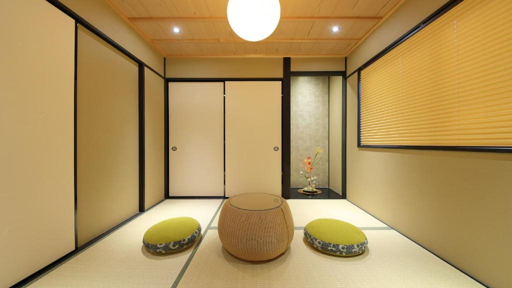 een Japanse kamer met 2 stoelen en een tafel bij Kyoto Ayanishiki Shimabara-Omon Residence【京都 Ayanishiki 島原大門邸】 in Kyoto