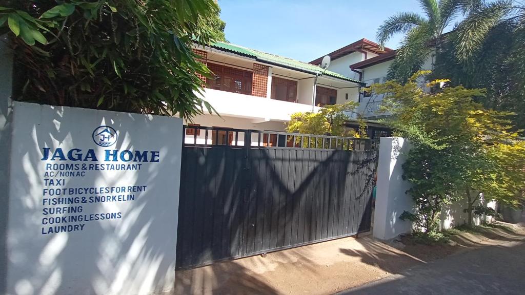 ein Zaun vor einem Haus mit einem Schild in der Unterkunft JAGA HOME in Tangalle