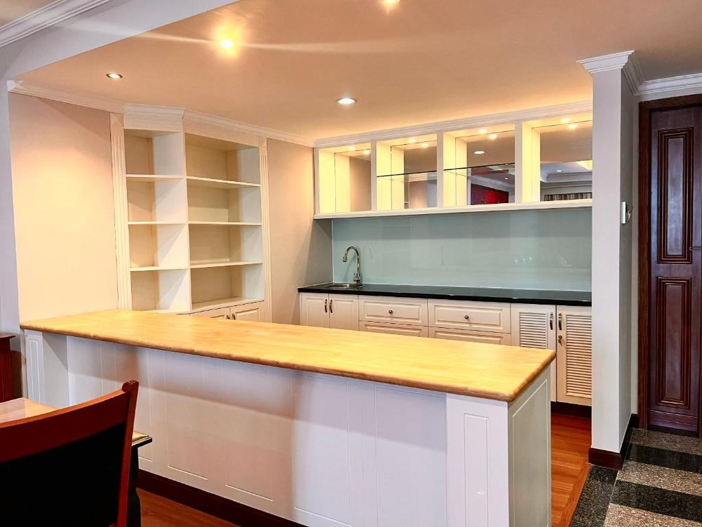 A kitchenette-style counter with a sink, open shelving, and mirrored storage.
