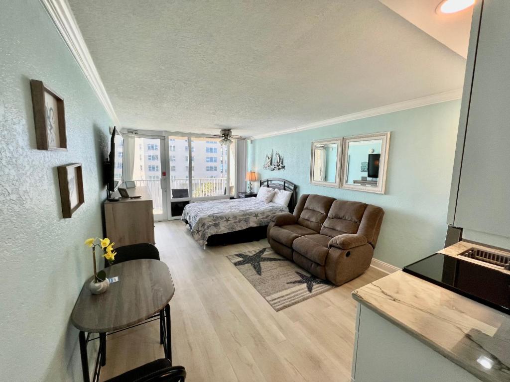 uma sala de estar com uma cama e um sofá em Pirates Cove 4th Floor Balcony Remodeled Condo em Daytona Beach