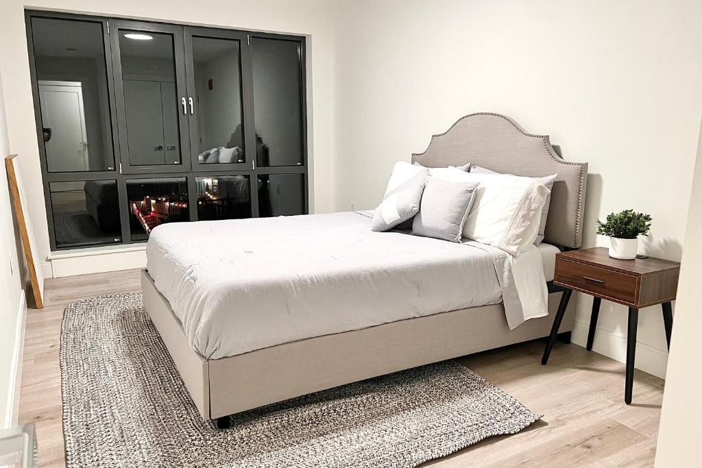 Un dormitorio con una cama con sábanas blancas y una ventana. en Modern 2 Bed Furnished Apartment in Quincy, en Quincy