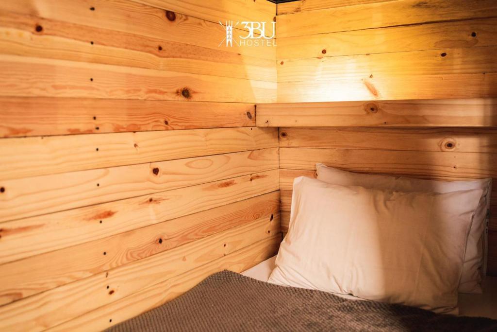 Zimmer mit einer Holzwand, einem Bett und einem Kissen in der Unterkunft 3BU Hostel Baguio - Session-Governor Pack in Baguio City