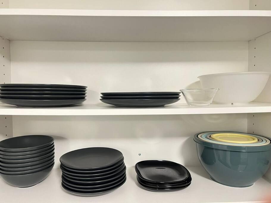 a bunch of plates and bowls on a shelf at Walking distance to St Boniface, easy parking in Winnipeg