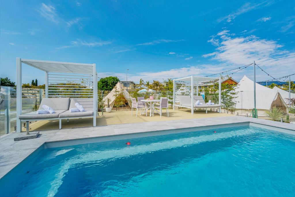 a swimming pool with chairs and a table on a patio at Camp Jordan in Port Macquarie