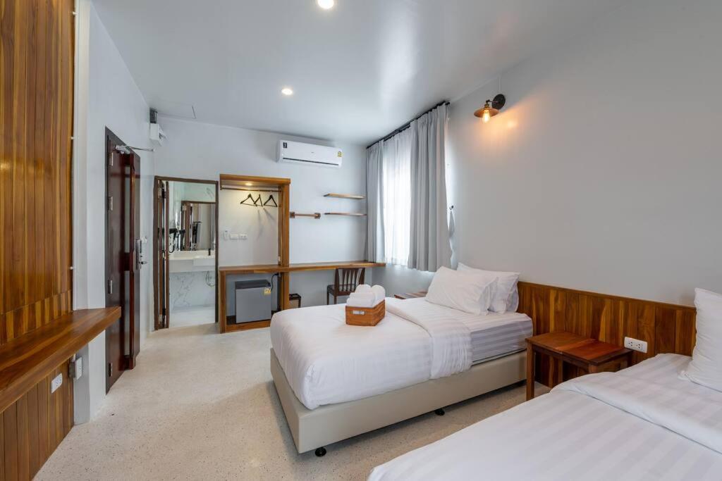 a hotel room with two beds and a mirror at U Villa Chiangkhan (อยู่วิลล่าเชียงคาน) in Chiang Khan