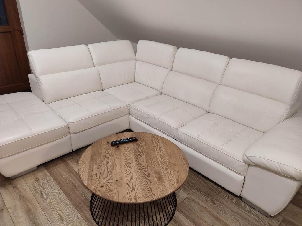 a white couch with a coffee table in a living room at Apartmán Tulipán in Hnúšťa