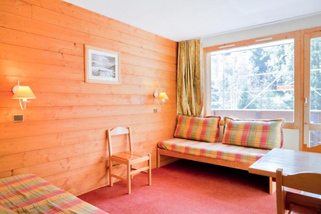 un salon avec un canapé et une fenêtre dans l'établissement Quartier La Forêt - maeva Home - Studio 3 Personnes Confort MAE-4169, à Valmorel