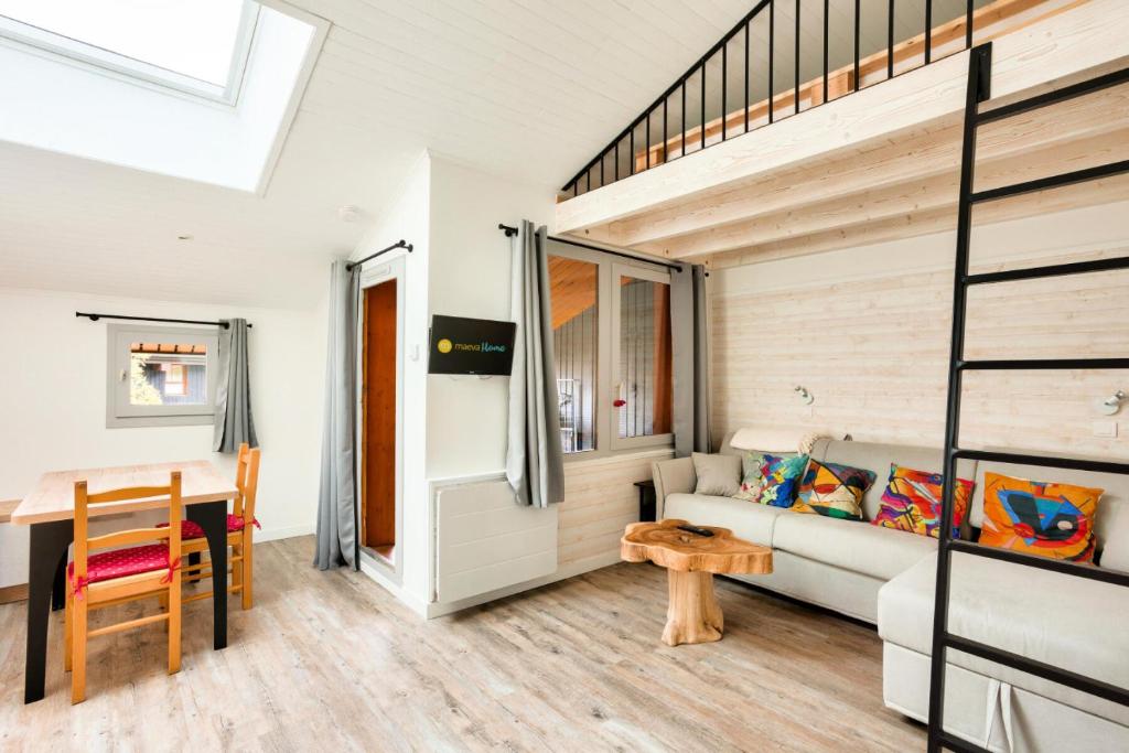 Cette chambre comprend une mezzanine et une table. dans l'établissement Les Résidences de Valmorel - maeva Home - Studio 4 personnes - Sélection 384, à Valmorel