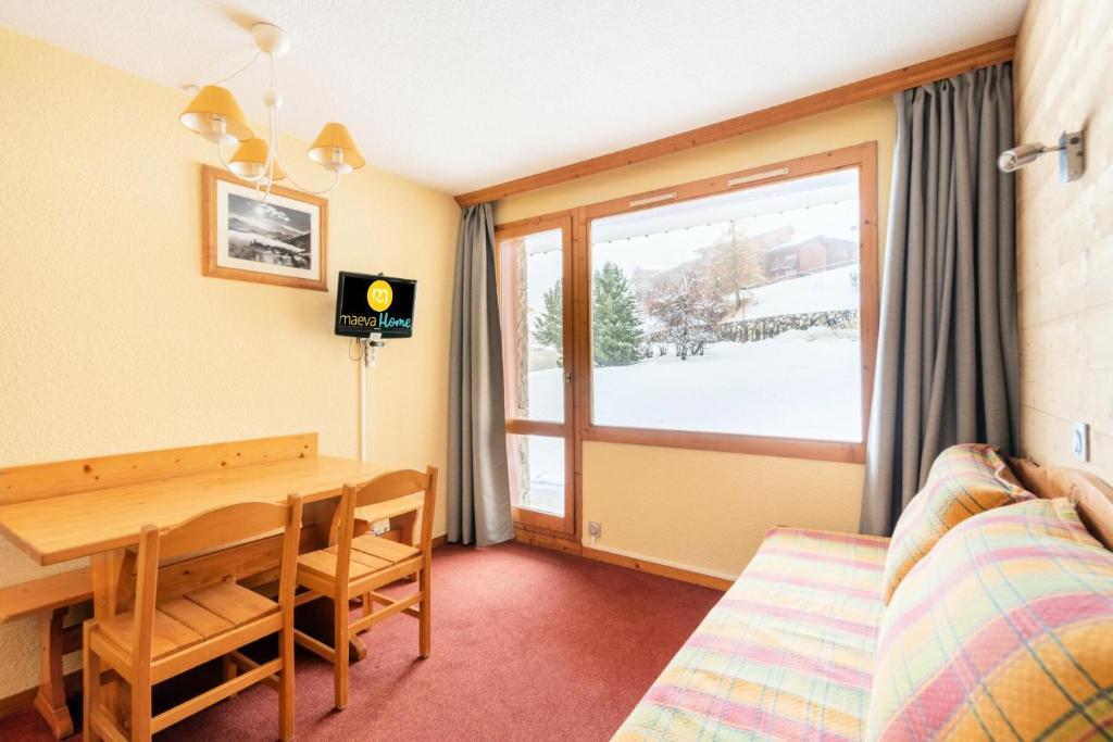 a room with a dining room table and a window at Les Résidences de Valmorel - maeva Home - 2 Pièces 5 Personnes Confort 76 in Valmorel