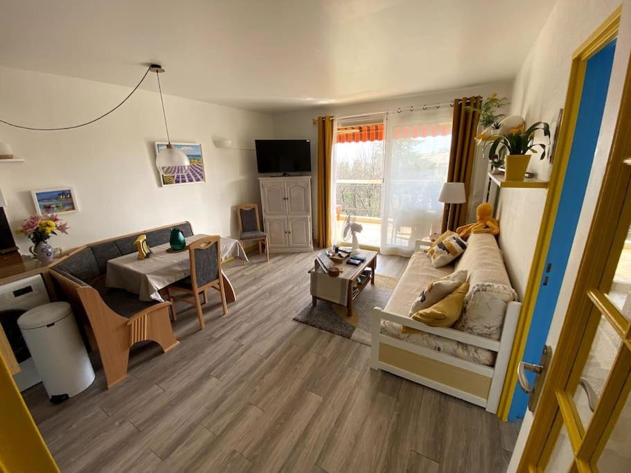 un salon avec un canapé et une table dans l'établissement Logement cosy, situé entre ciel et mer, à Vence