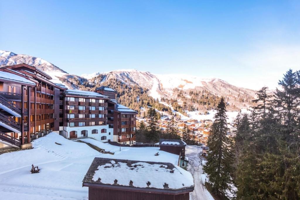 un complejo en las montañas con nieve en el suelo en Les Résidences de Valmorel - maeva Home - 2 Pièces 5 Personnes Confort 51, en Valmorel