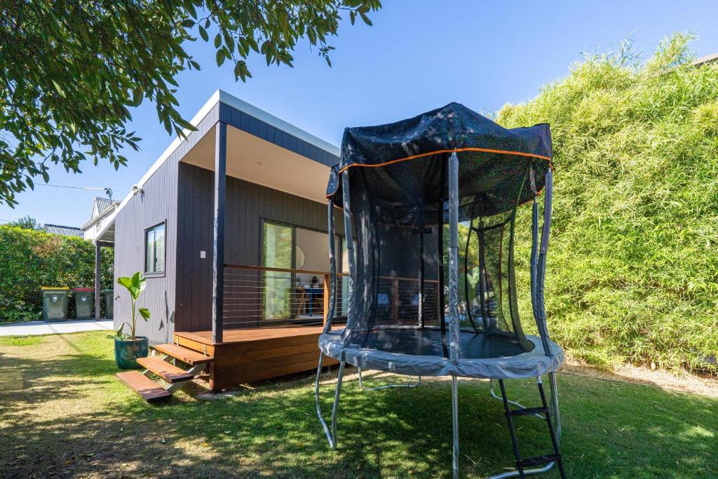 a small house with a trampoline in the yard at Cozy 1 Bed 1 Bath Tiny Home near CBD in Brisbane
