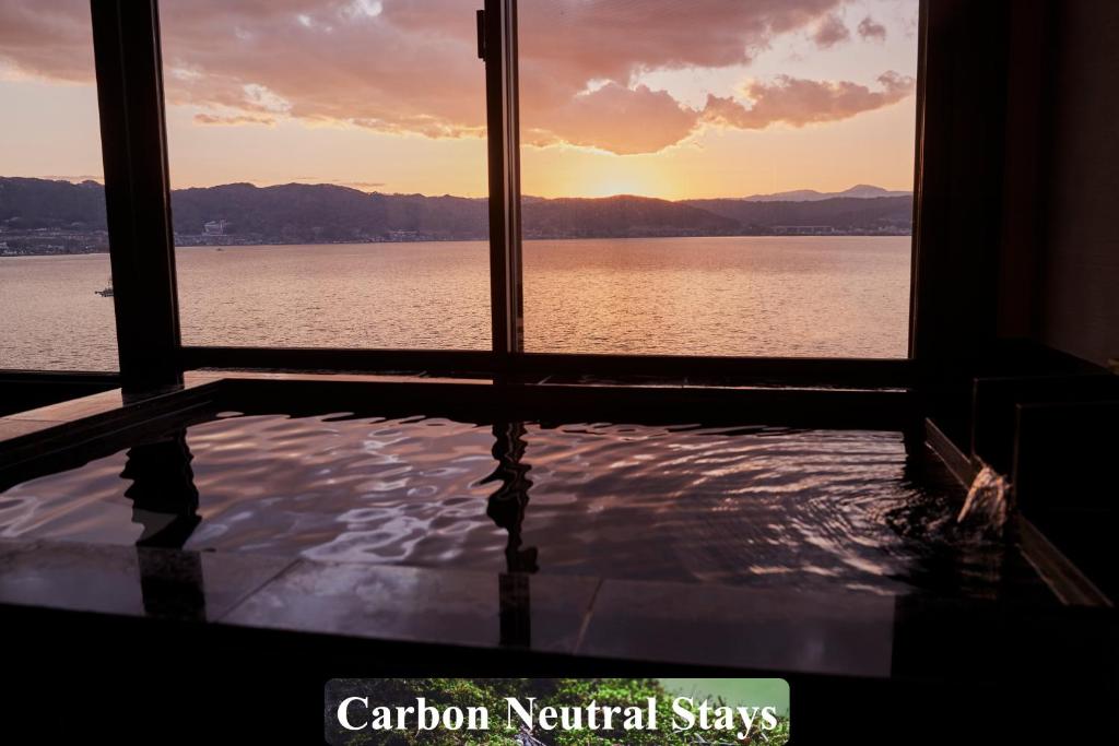 Habitación con ventana y vistas al agua. en Kamisuwa Onsen Shinyu en Suwa