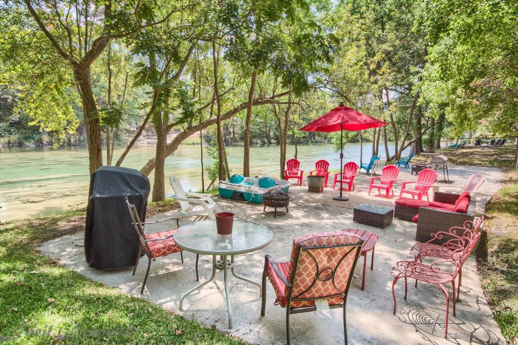a group of chairs and tables and a table and umbrella at Guadalupe Retreat RR 1324 in New Braunfels