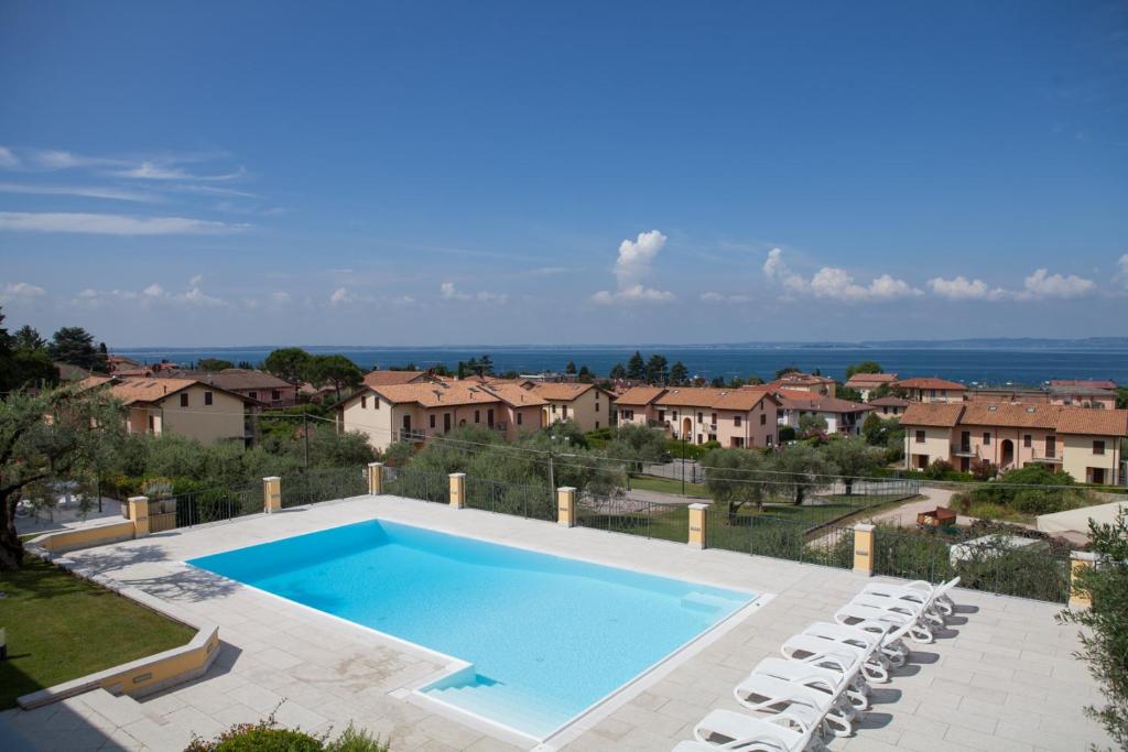 a large swimming pool with chairs and houses at Villa Sergio in Bardolino