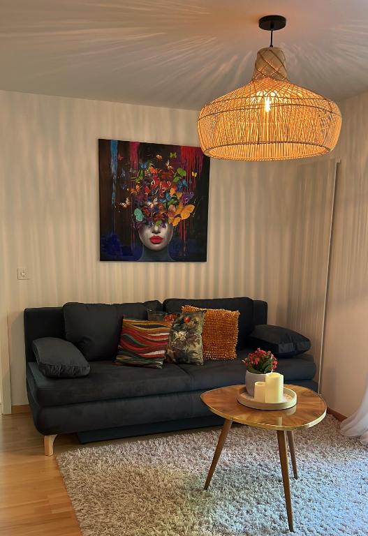 ein Wohnzimmer mit einem schwarzen Sofa und einem Tisch in der Unterkunft Löw in Luzern