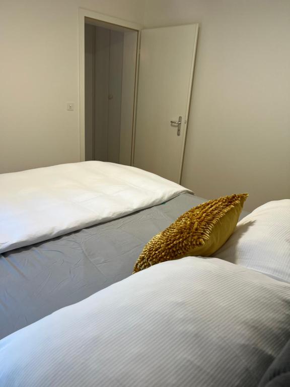 una camera con due letti e un cuscino giallo di Löw a Lucerna