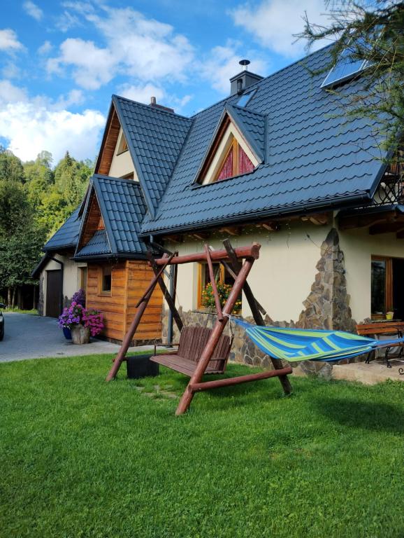 a house with a hammock in front of it at Chatka Zuzia in Poronin