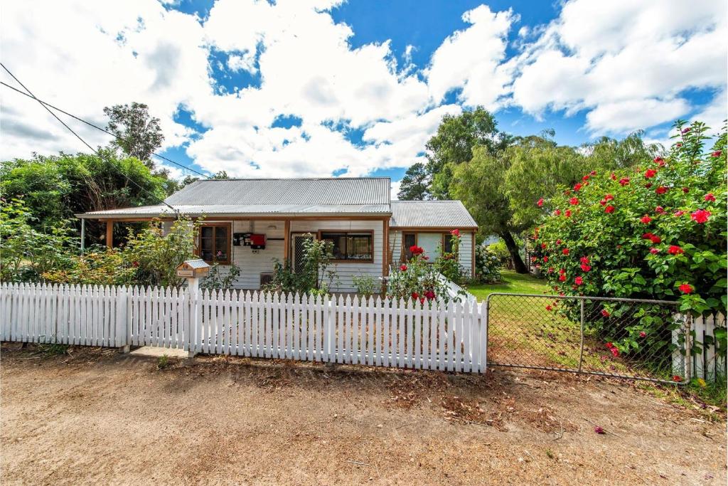 a small white house with a white picket fence at Rose Cottage Nannup in Nannup