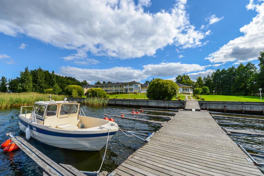 a boat is docked at a dock on the water at Hotel Sea Front in Ekenäs