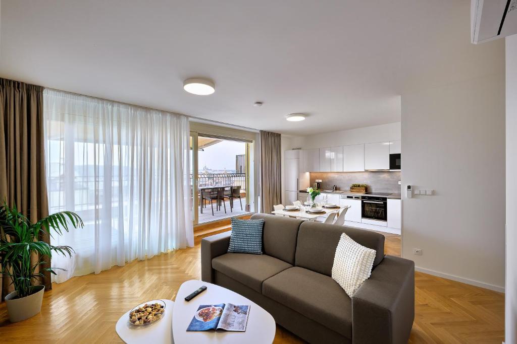 een woonkamer met een bank en een tafel bij DownTown Suites Rubesova in Praag