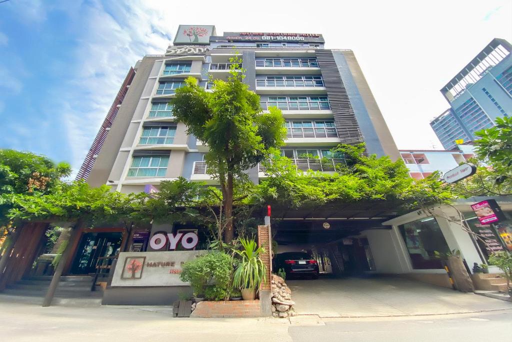 a tall building with a tree in front of it at Super OYO Capital O 564 Nature Boutique Hotel in Bangkok
