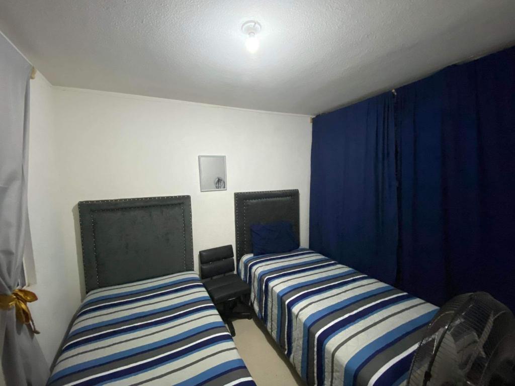 阿瓜斯卡連特斯的住宿－Casa para descanso，配有蓝色窗帘的客房内的两张床