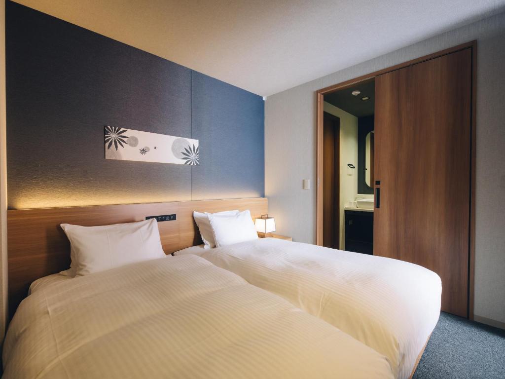 Postel nebo postele na pokoji v ubytování MIMARU SUITES Kyoto Shijo