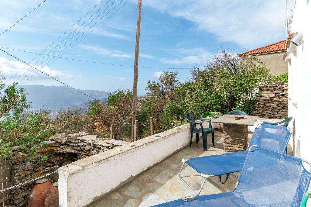 a patio with chairs and a table on a wall at Anemodroulis Kochilos Andros 4ppl in Kókhilos