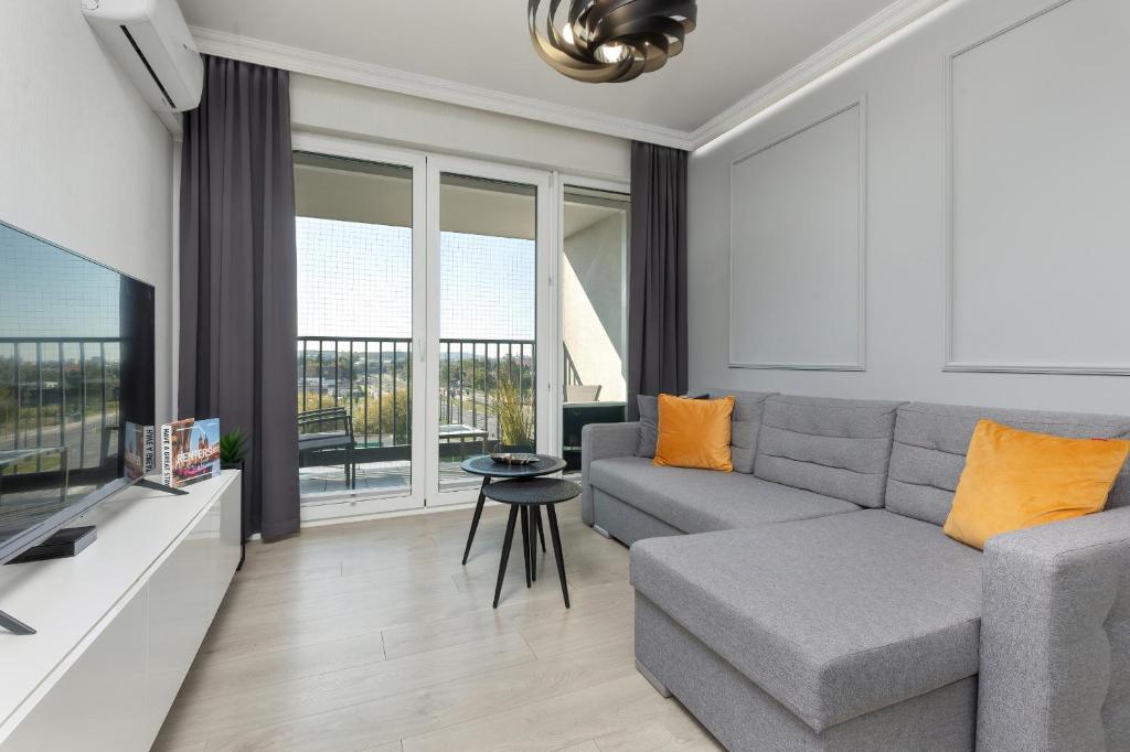 een woonkamer met een bank en een tv bij Podgórze Lipska Pet-friendly Apartment with Balcony and Parking by Renters Prestige in Krakau