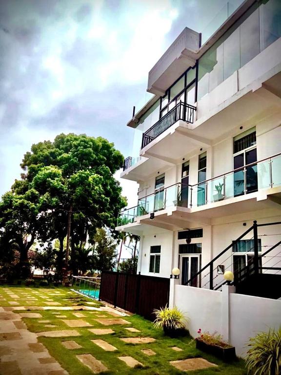 a white building with a fence and a yard at Florence Villas in Jaffna