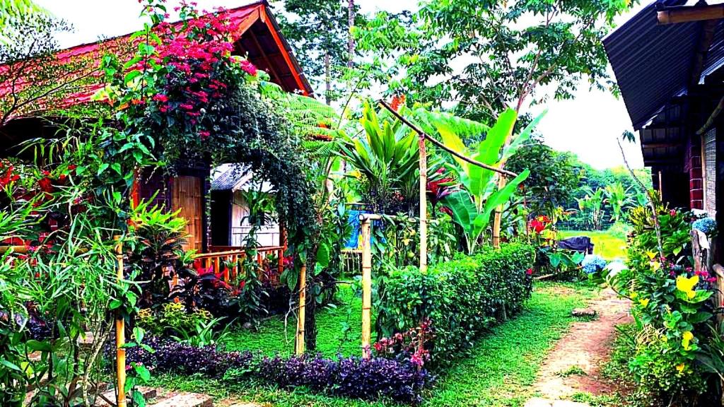 a garden with flowers on the side of a house at Ariel Bungalow Tetebatu in Tetebatu