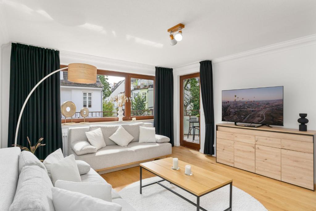 a living room with a couch and a tv at Modern Oak-Apartment für bis zu 6 Personen in Bremen