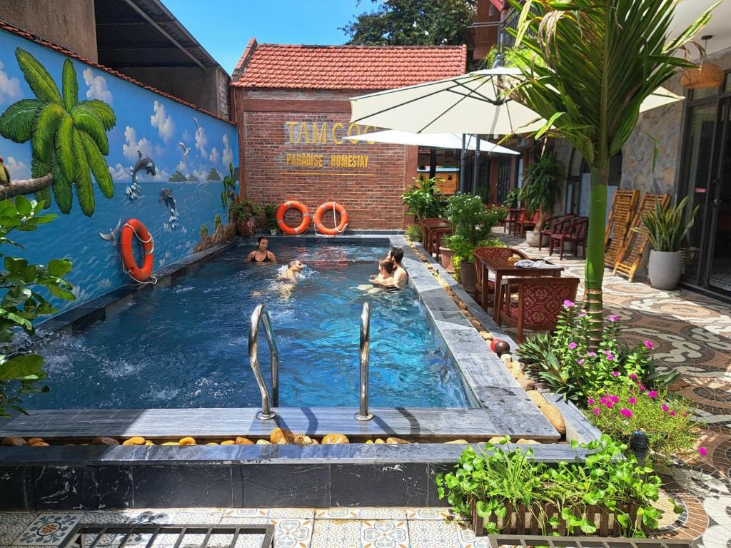 una piscina con due persone dentro con gente che nuota di Tam Coc Paradise Homestay a Ninh Binh