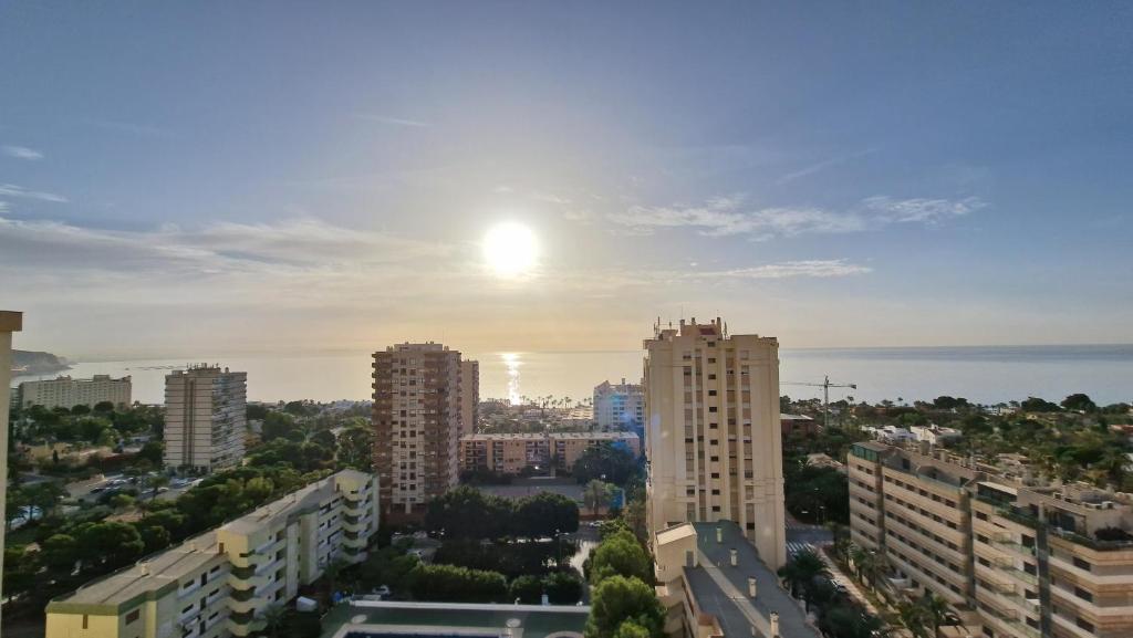 a view of a city with the sun in the sky at PALM TOWER APARTMENT in Roquetas de Mar