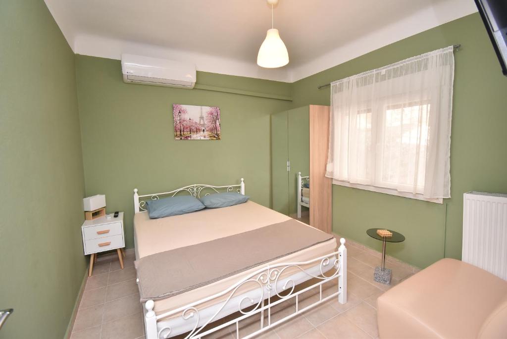 a green bedroom with a bed and a window at Prive Apartment Thessaloniki-Easy Parking in Thessaloniki