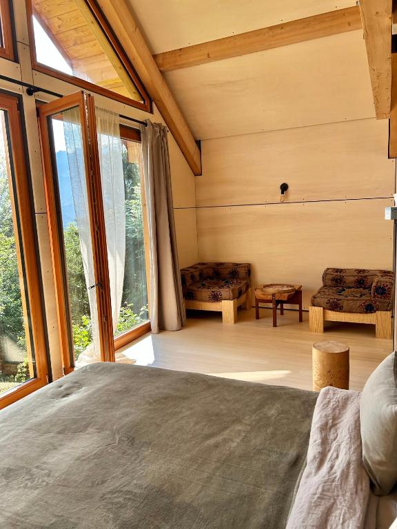 a bedroom with a bed and a large window at Le Cabanon in Saint-Jorioz