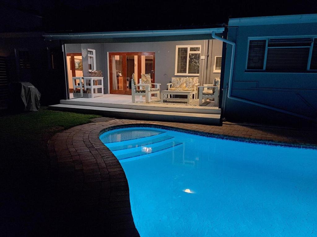 a swimming pool in front of a house at night at Luxury Living On Westview in Port Elizabeth