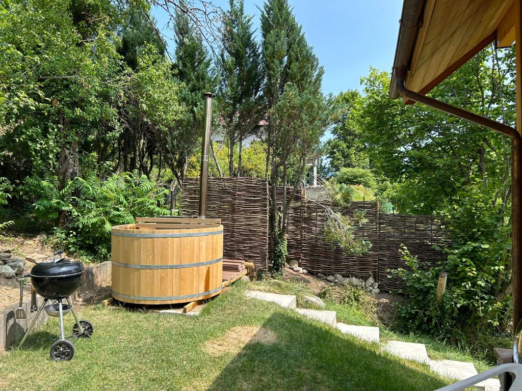 a wooden barrel in a garden with a grill at Le Cabanon in Saint-Jorioz