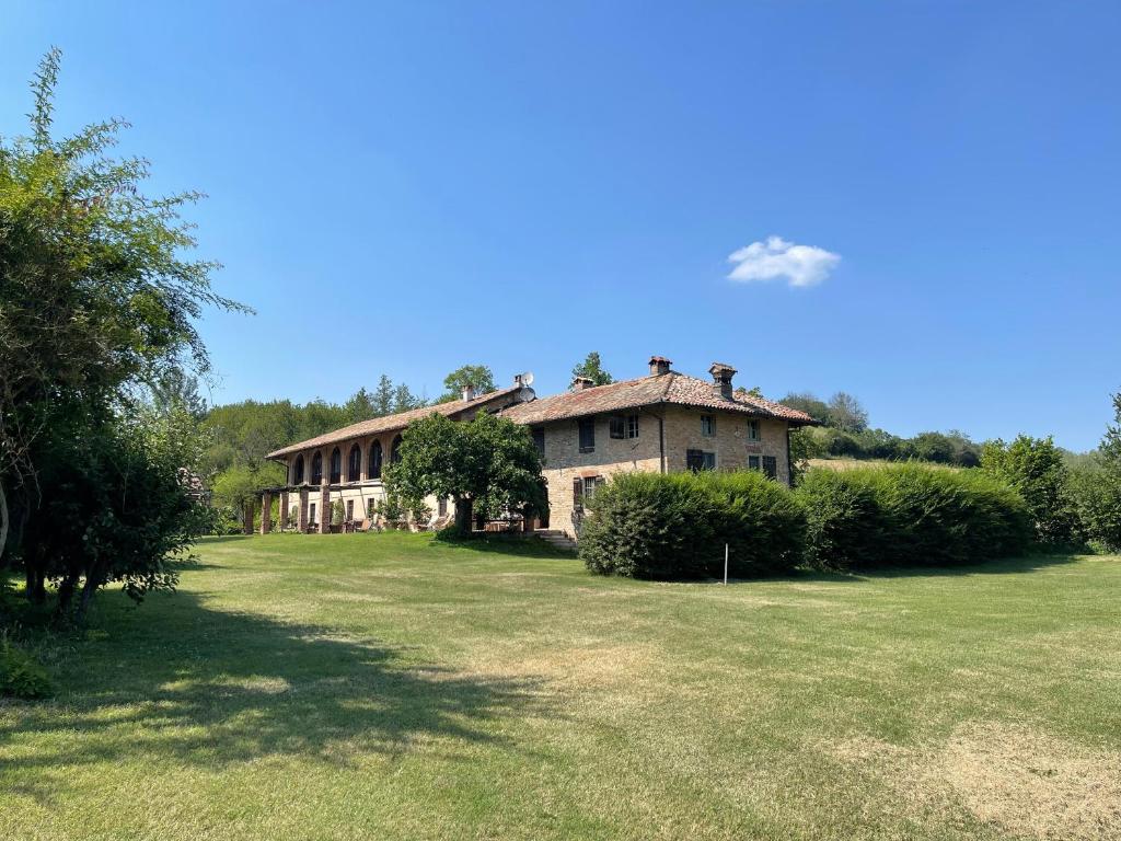 a large house with a grass yard in front of it at La Verbia in Sciolze