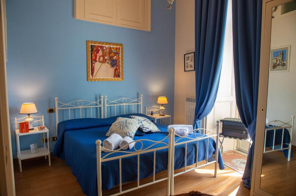 een slaapkamer met een blauw bed met een teddybeer erop bij B&B Residenza Via Dei Mille in Napels