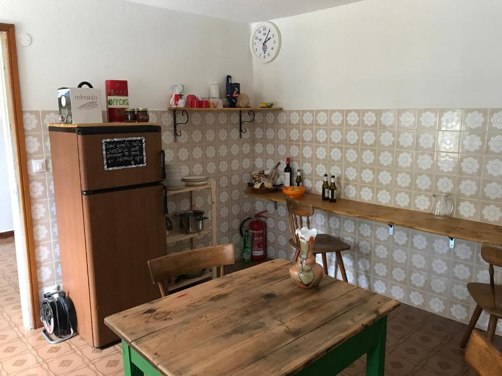 cocina con mesa de madera y nevera en Ostello Casa Morit, en Pontebba