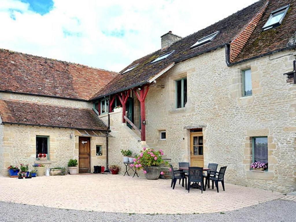 a building with chairs and a table in front of it at Le Poulailler 