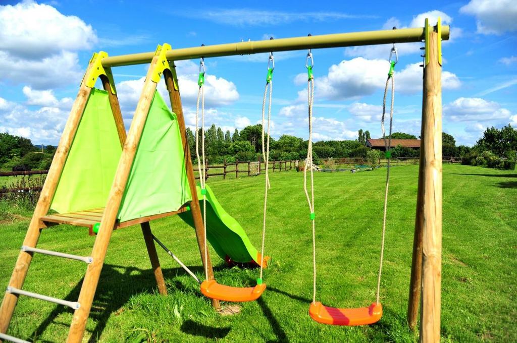 a swing set in a park with a green tent at La Grange 