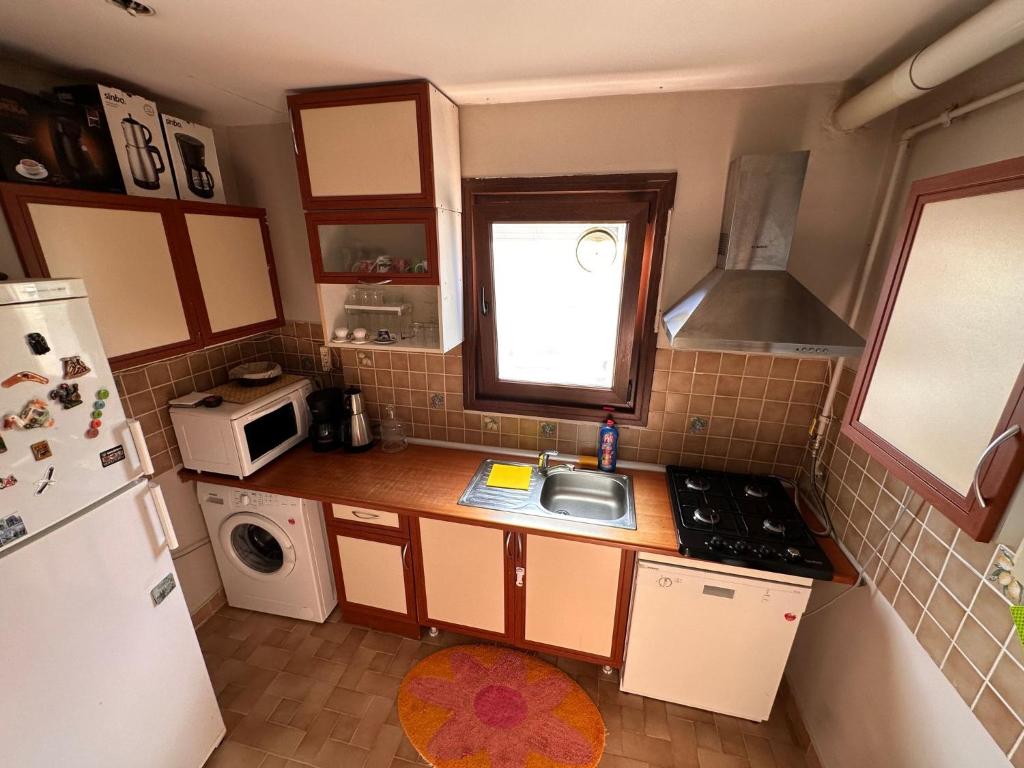 a small kitchen with a sink and a refrigerator at Historic Wooden House with Bosphorus view in Sarıyer